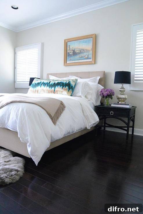 Beige bedroom accented with teal pillow and throw