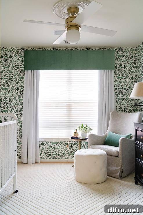 Green and white nursery with a gray wingback glider and forest wallpaper