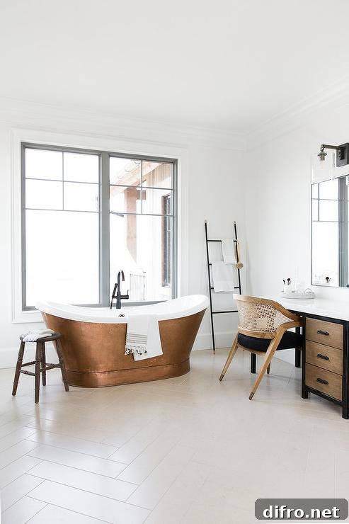 Copper bathtub with matte black fixtures and off-white herringbone tiles