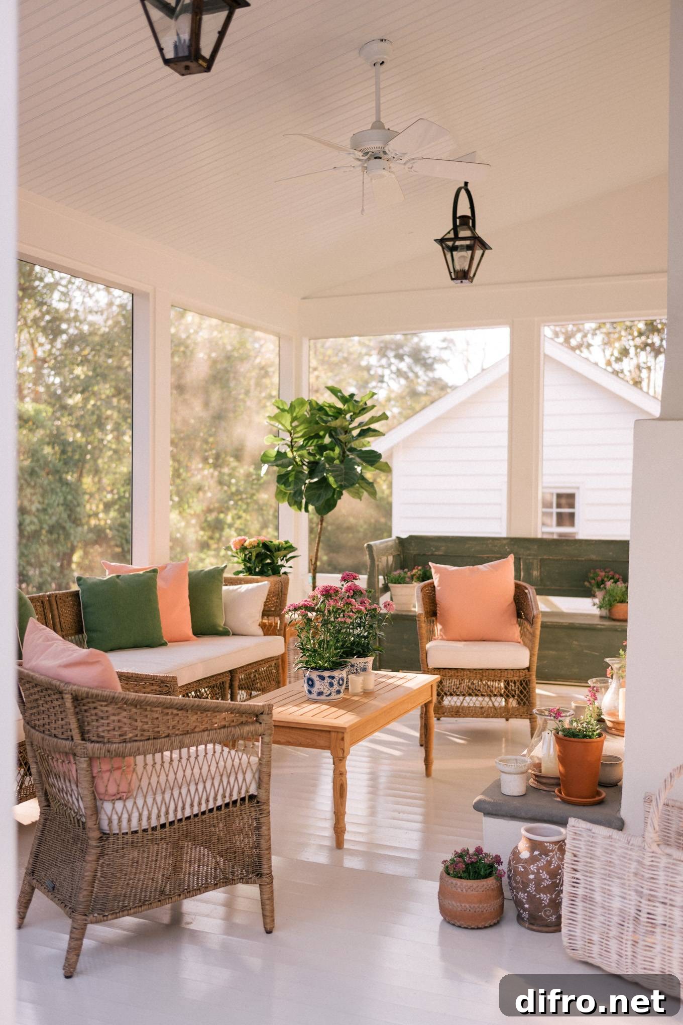 outdoor porch with woven furniture, pink and green pillows and floral accents