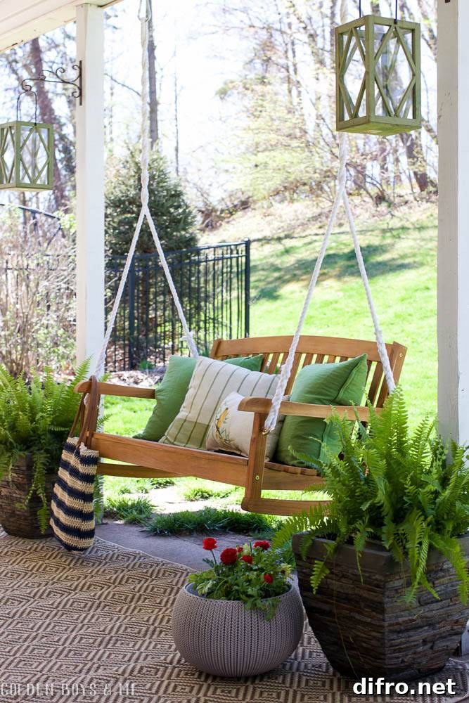 wooden patio swing chair with bright green pillows