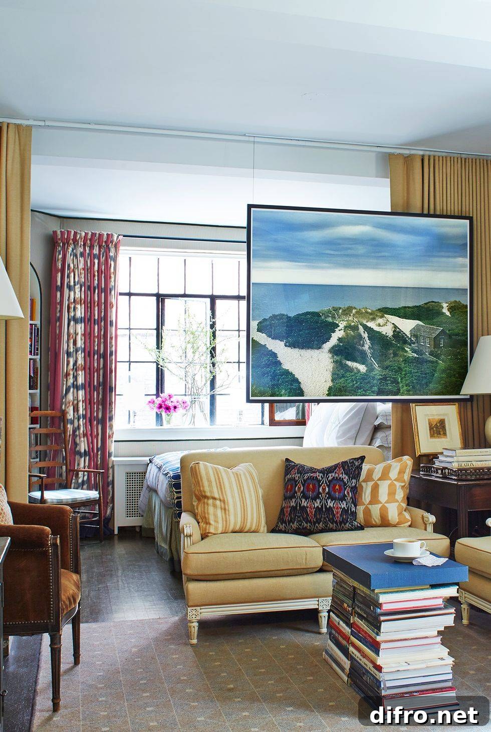studio apartment with yellow couch hanging floating art and book stack coffee table