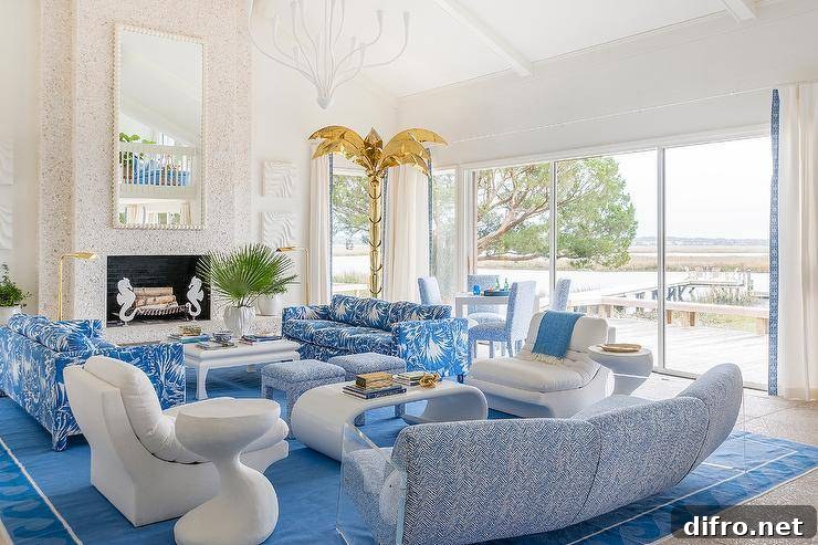Blue palm leaf sofas and blue chevron pattern stools join with a white chinoiserie coffee table in a living room with a stone fireplace.