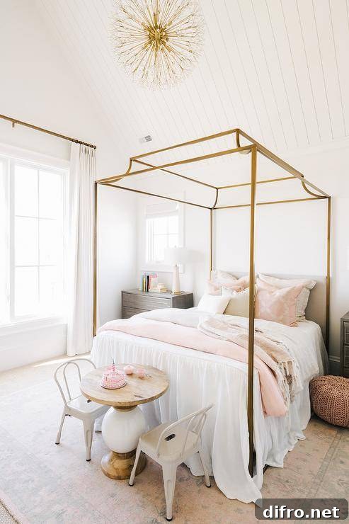 Chic girl's bedroom features a gold canopy bed with white and pink bedding flanked by nightstands and a pink pouf.