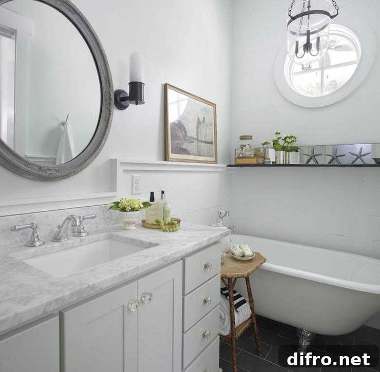Amazing beachy cottage bathroom with vintage clawfoot tub, charcoal gray slate tiles, pale gray single bathroom cabinet vanity with marble countertop.