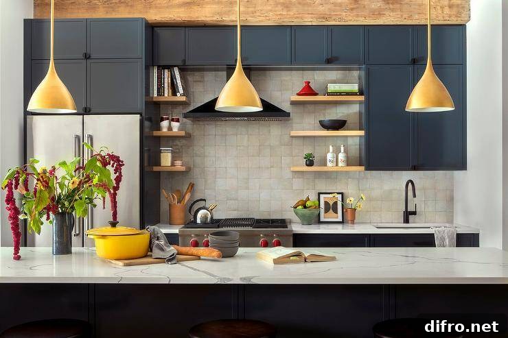 Three gold Aerin Agnes Pendants hang over a marble-look countertop accenting a black center island in a well appointed black kitchen.