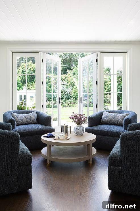 Living room features dark blue boucle lounge chairs with a gray shagreen coffee table
