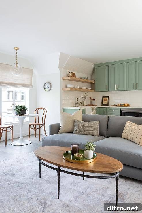 a charcoal gray sofa accented with beige pillows faces a wood and metal coffee table, positioned atop a light gray rug