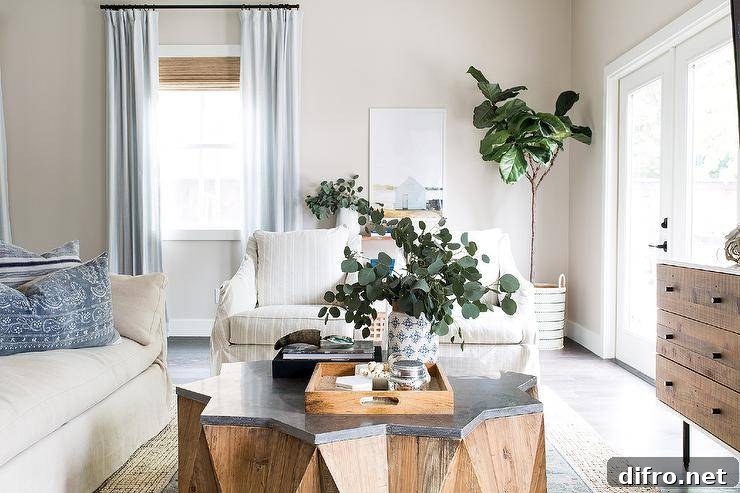 Wood and concrete starburst coffee table surrounded by a linen sofa and a fiddle leaf fig plant