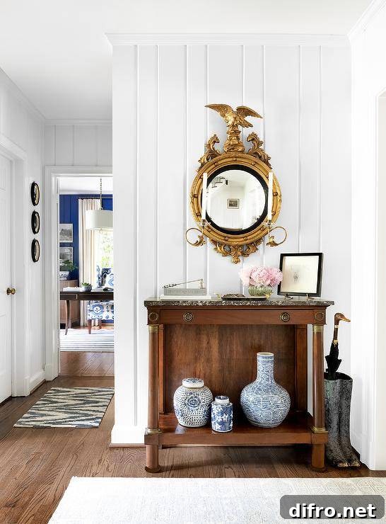 Antique console table with black marble countertop, Chinese ginger jars, and a gold eagle mirror.