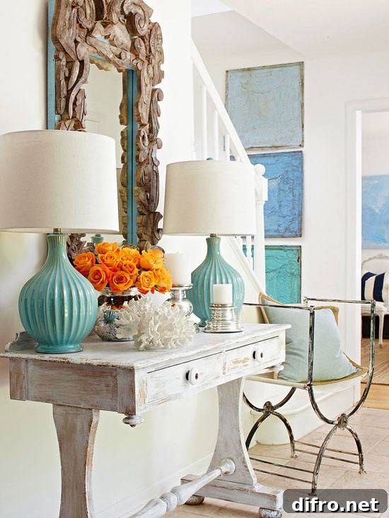 Gray and turquoise entryway with driftwood framed mirror and turquoise lamps.