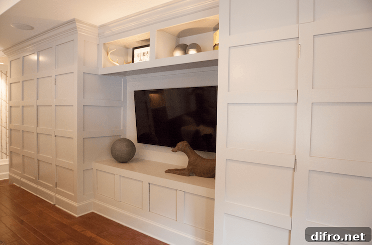 Incredible light gray wall to wall entertainment center with hidden doors for concealed storage.