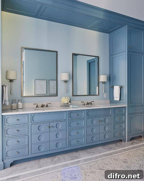 Glam blue bathroom with a blue double washstand in a built-in nook, white quartz countertop and framed vanity mirrors.