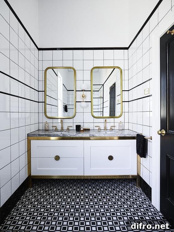 Curved brass mirrors on a black-and-white tiled wall above a white dual washstand with brass trim and gray marble countertop.