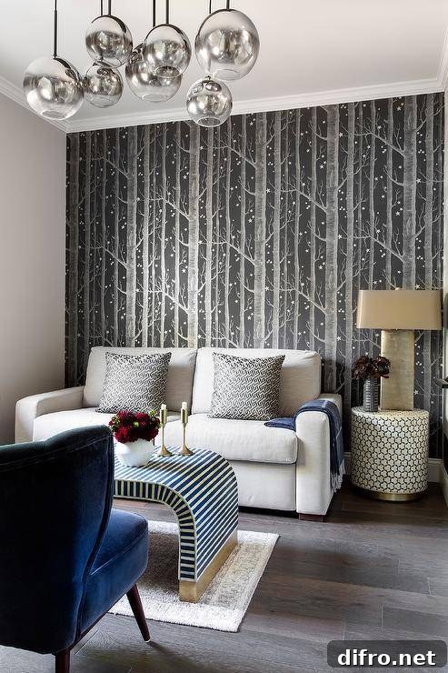 Cole & Son Woods Wallpaper covers an accent wall positioned behind a white loveseat topped with black Greek key pillows.