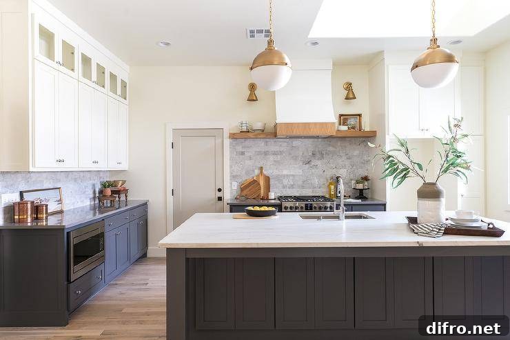 Glass front cabinets are stacked over white shaker cabinets contrasting black shaker base cabinets fitted with a microwave drawer located under a honed marble countertop.