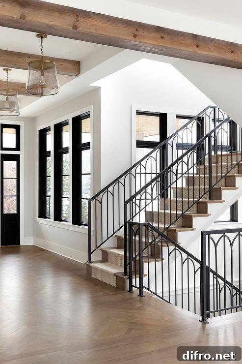 A stunning ornate wrought iron staircase with oak treads and a chevron runner.