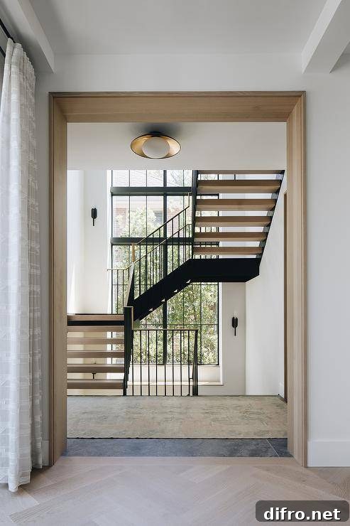 Floating staircase with gold and black railing illuminated by natural light.