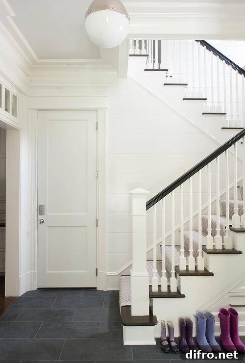White staircase accented with a gray geometric runner and black railing.