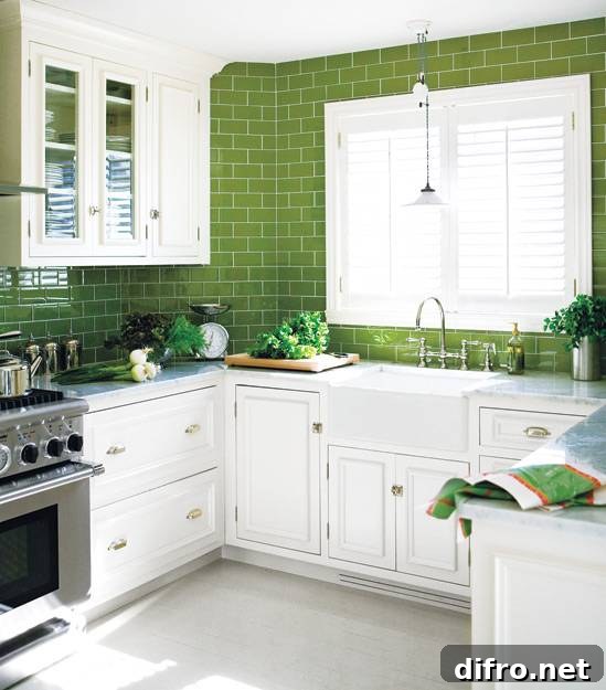 White and green kitchen with crisp white cabinets paired with carrara marble countertops and green subway tile backsplash. Vintage barn pendant light hangs over farmhouse sink with polished nickel bridge faucet. U shaped kitchen features stainless steel appliances and green leafy accents.