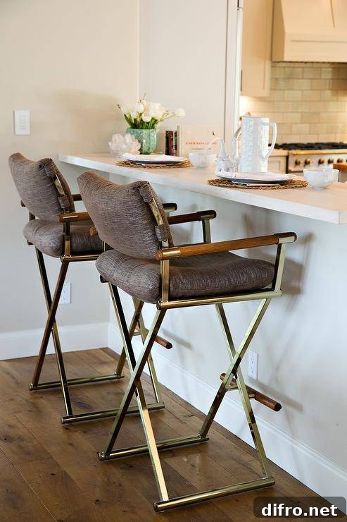 A white kitchen peninsula paired with vintage folding bar stools