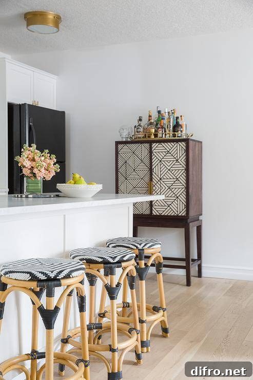 Backless rattan stools at a white kitchen peninsula