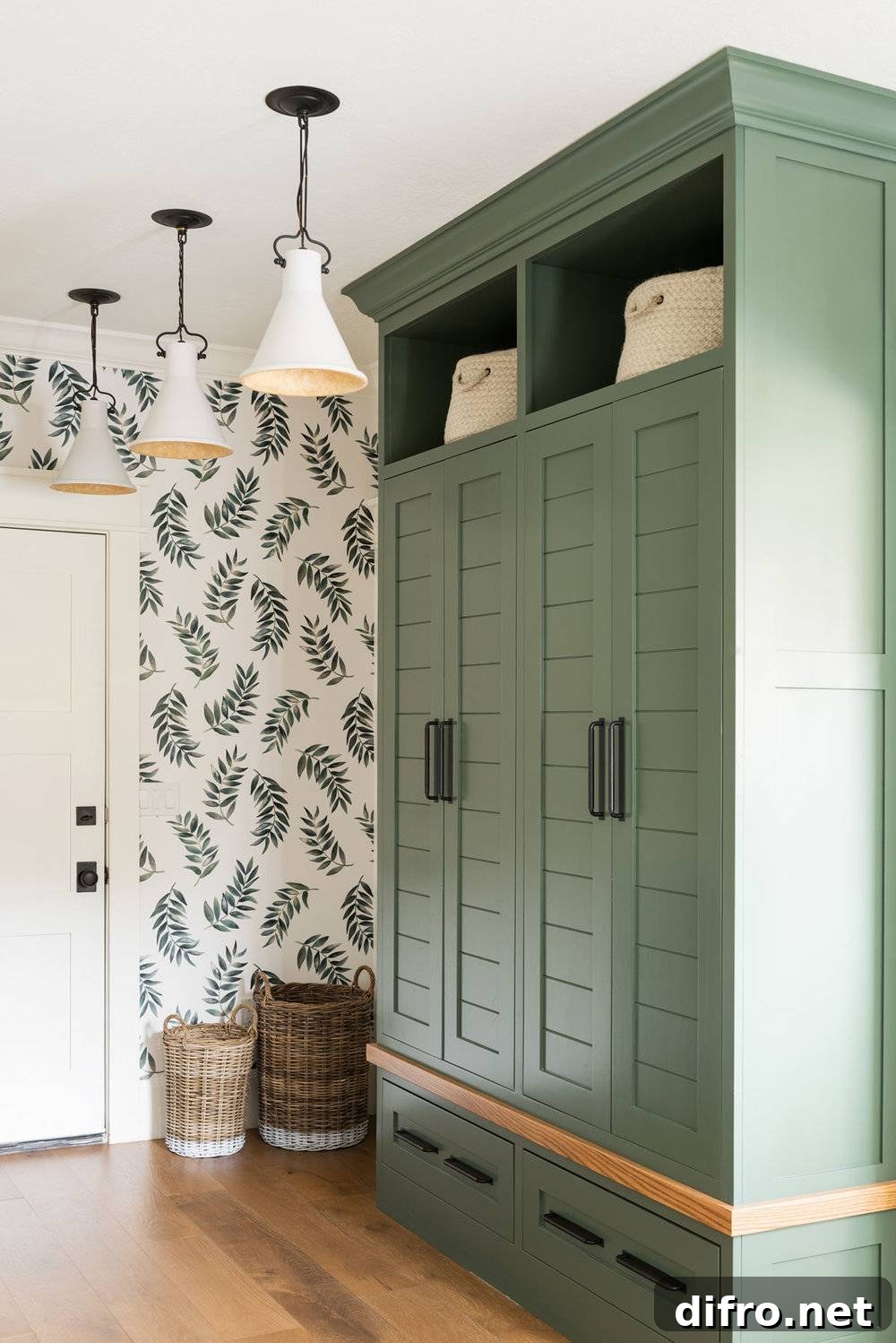 Wardrobe painted sage with complementary wallpaper and baskets