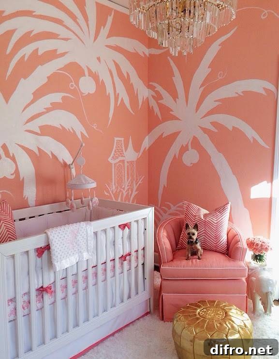 Coral pink nursery with a hand-painted palm tree mural and art deco chandelier.