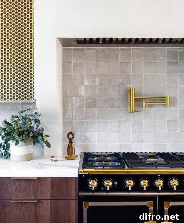Brass pot filler over a black French stove with gray tiles