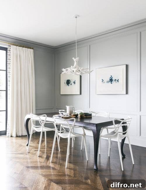 Beautifully designed contemporary dining room with gray paneling and crown molding.