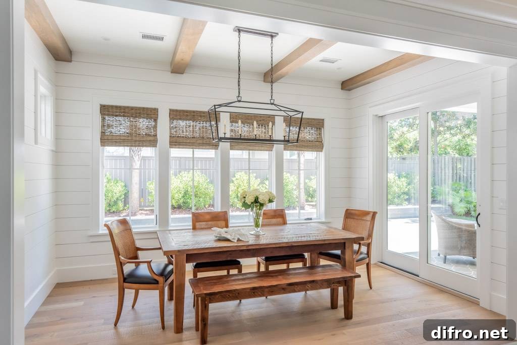 A dining room with white shiplap, a wooden table and chairs.
