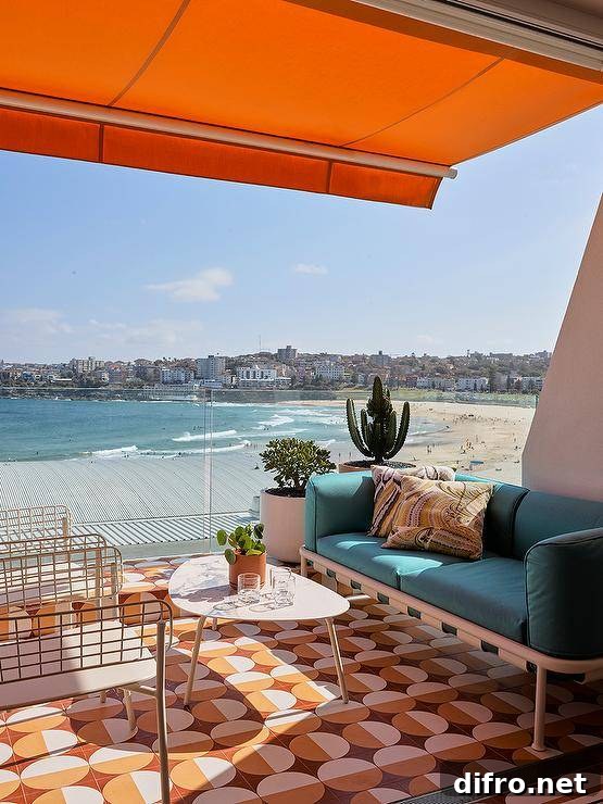 Balcony features orange and yellow mosaic floor tiles, a marble top coffee table and a turquoise blue sofa under an orange awning.