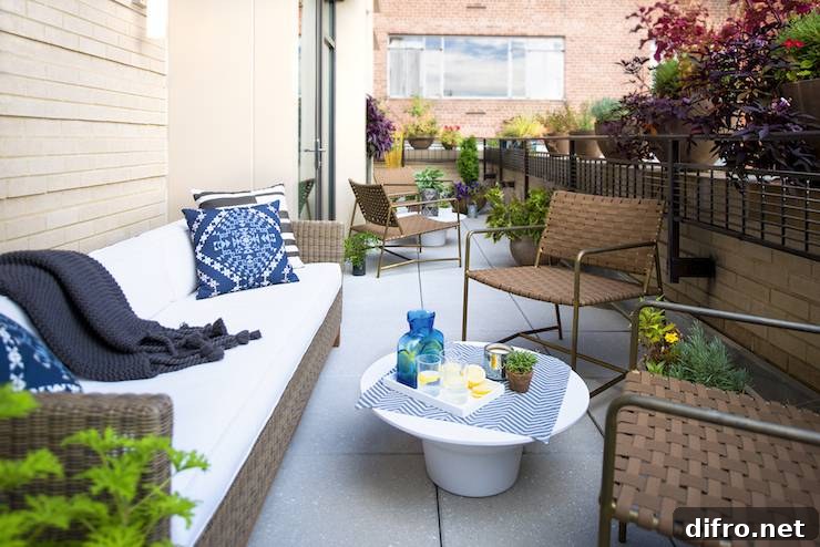 Private apartment terrace features outdoor woven sofa topped with white seat cushions and indigo pillows.