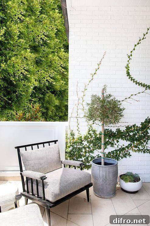 Patio features white brick walls with ivy and a black wooden outdoor chair.