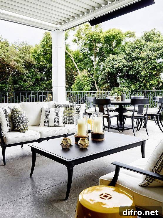 Covered patio design features a black and white outdoor sofa with yellow and black pillows.