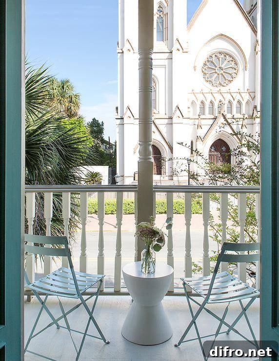 Chic balcony is filled with blue slatted folding chairs and a white hourglass accent table.