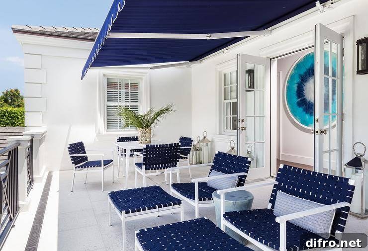 Under a navy blue balcony awning, navy blue basketweave chairs are topped with blue stripe pillows.