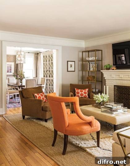 Classically restored 1930s bungalow, featuring bunny williams lamp, oly studio astro table, Cecilia chair, Moroccan rug, pale gray walls, leather ottoman, and hickory chair sofa.