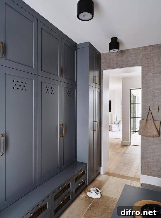 Stacked show drawers donning brass pulls are fixed beneath a blue mudroom bench top mounted under blue closed lockers.