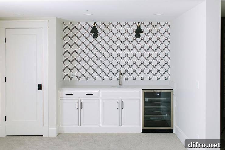 Black and white basement wet bar with quatrefoil wallpaper, shaker cabinets, and a mini wine cooler.