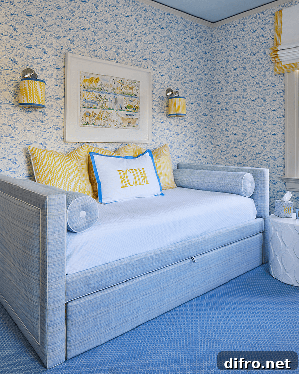 Nickel sconces with yellow and blue shades flank an art piece hung from a blue wallpapered wall over a blue daybed.