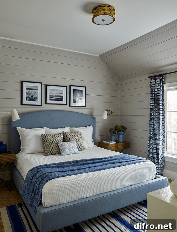 Blue and gray bedroom design features a blue upholstered bed with blue and white bedding flanked by X base bedside tables.