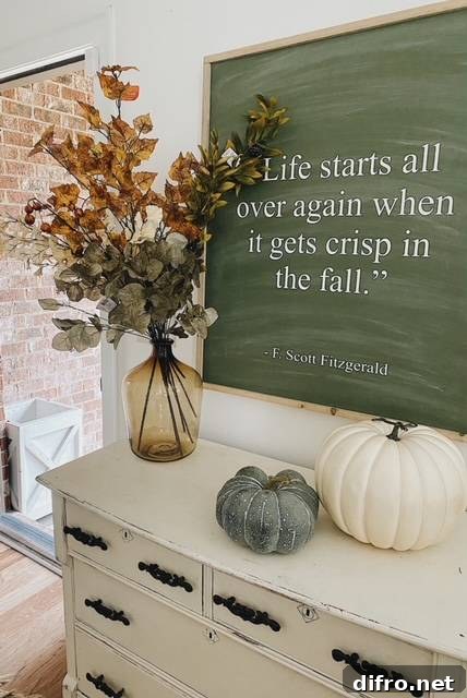 Simple fall entryway decor with pumpkins and large quote about fall.