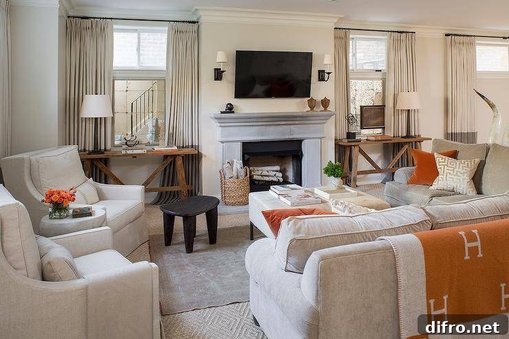 Chic gray living room features a gray sectional draped in an orange blanket and lined with pumpkin orange velvet pillows.