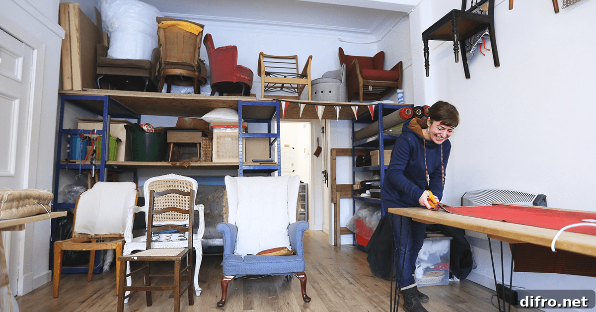 Person cutting fabric on a table surrounded by chairs that require upholstery.