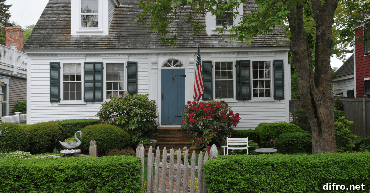 Older Cape Cod style house with American flag upfront.