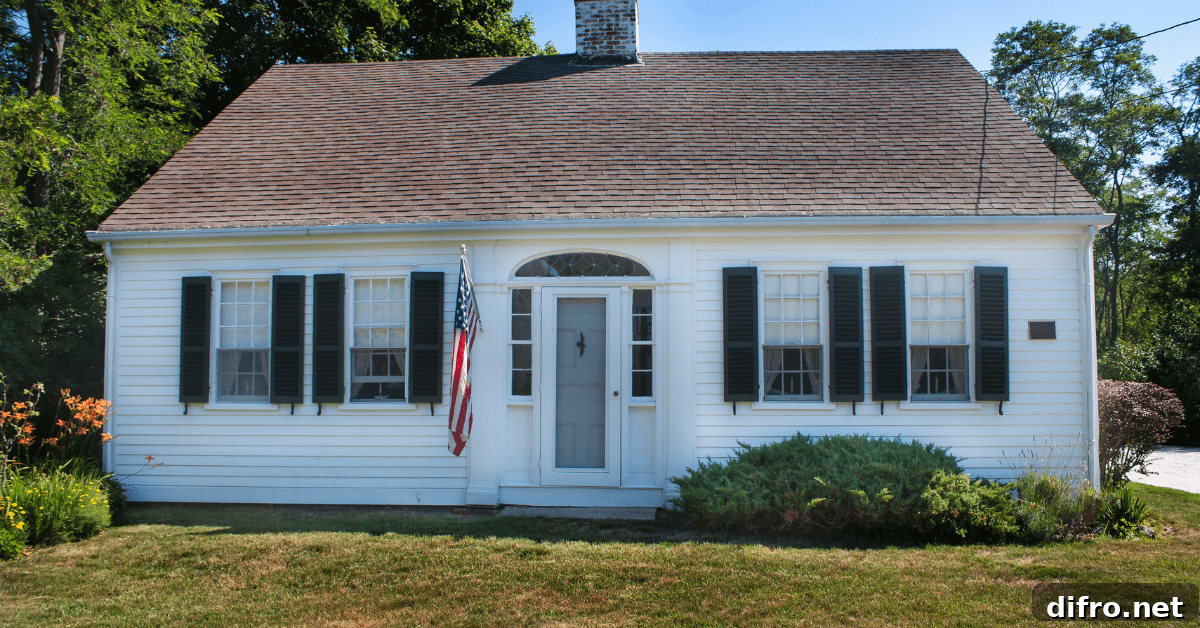 Small Cape Code house with America flag mounted by the front door.