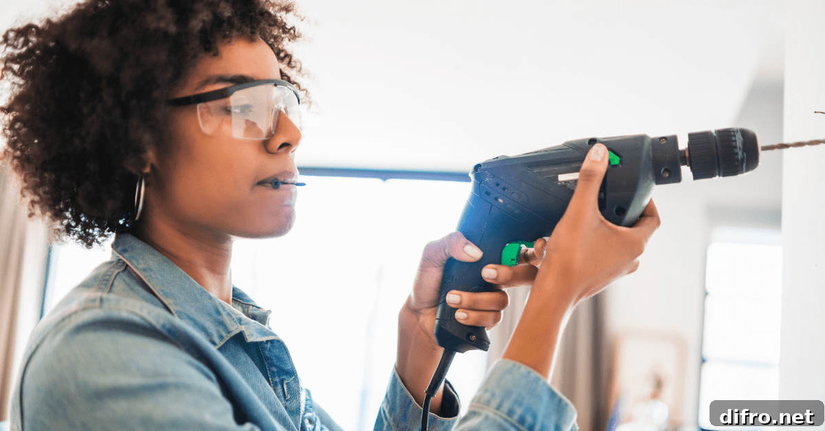 Person using drill while wearing eye protection.