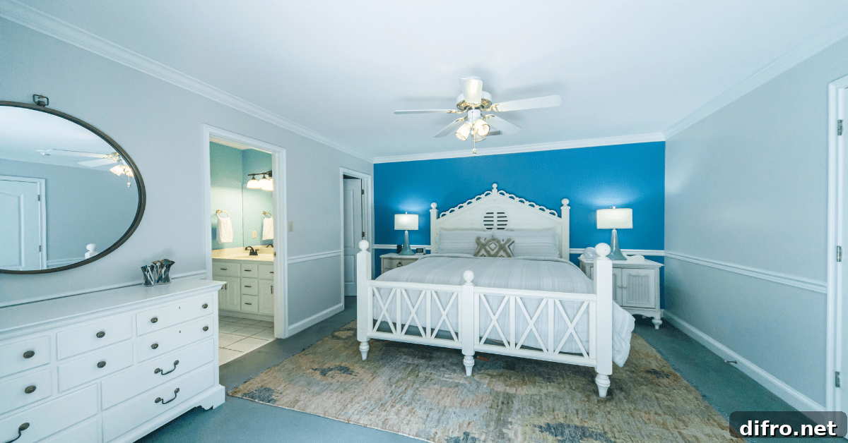 Bedroom with bed, rug, and white furniture.