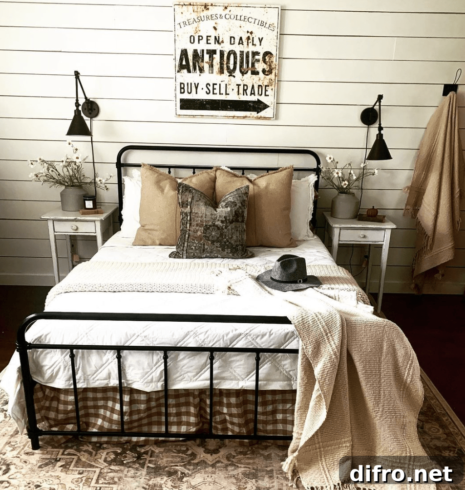 vintage sign in bedroom hanging above bed antiques white bedding black iron bed wall sconces